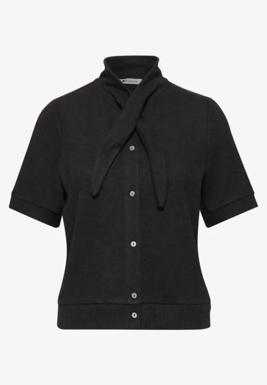 Schwarze Strickbluse mit kurzen Ärmeln, Knopfleiste und angenähter Bändchenschleife am Kragen.