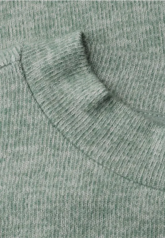 Nahaufnahme eines grünen Strickpullovers mit Kapuzenansatz