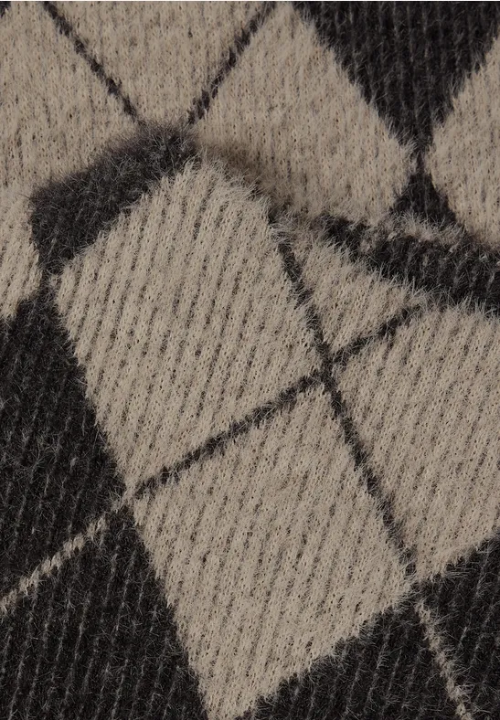 Close-up van een gebreide stof met zwart-beige ruitmotief.