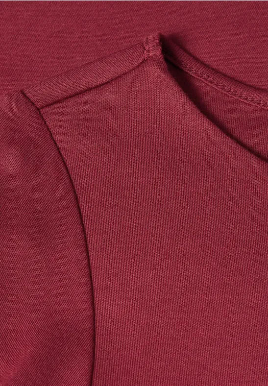 Close-up van een mouwloos bordeaux shirt van zacht jersey.