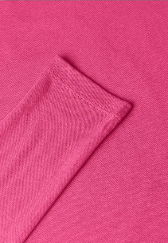Close-up van roze katoenen stof met net gestikte rand.