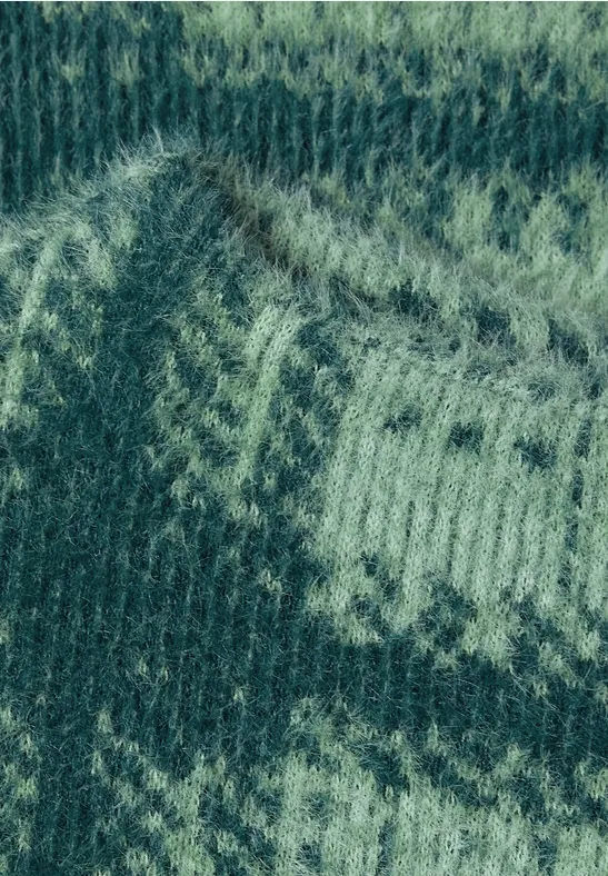 Groen gebreid patroon met lichtere zigzag-ornamenten, Fair Isle-stijl.
