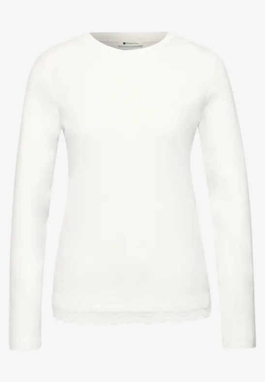 Weißes Langarmshirt mit Rundhalsausschnitt und Spitzenbesatz am Saum.