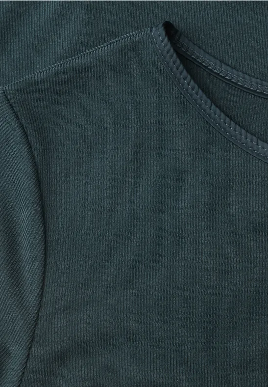Close-up van een donkergroene, fijngeribbelde T-shirt met ronde hals.