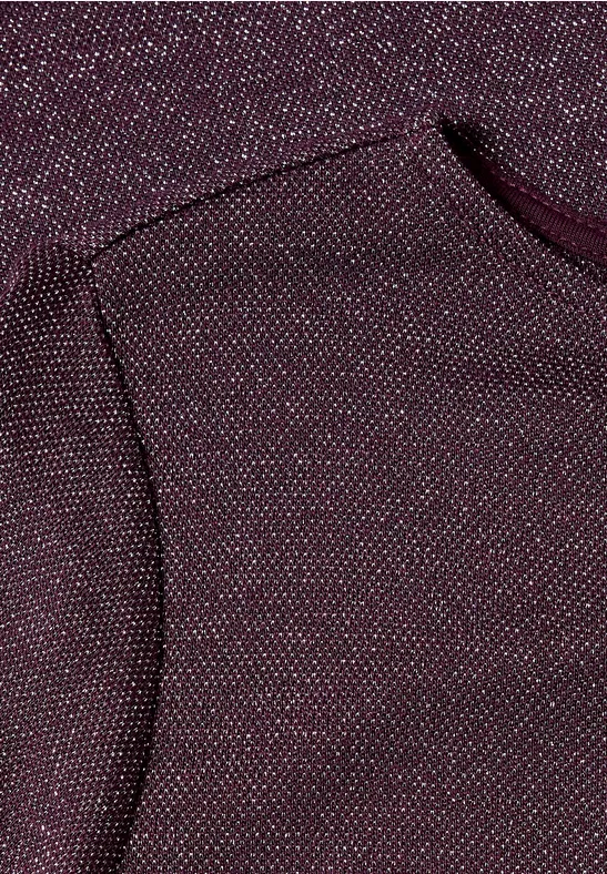 Nahaufnahme eines weinroten Strickstoffs mit bunten Sprenkeln und abgerundeter Naht.