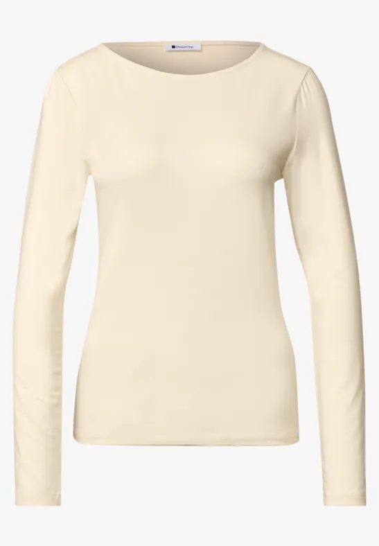 Crèmekleurig damesshirt met lange mouwen en ronde hals.