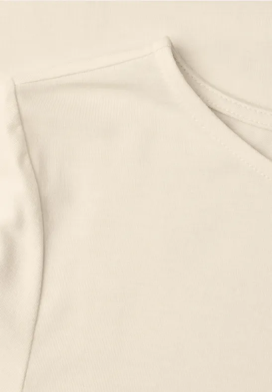 Close-up van een lichtbeige katoenen T-shirt met ronde hals en korte mouw.
