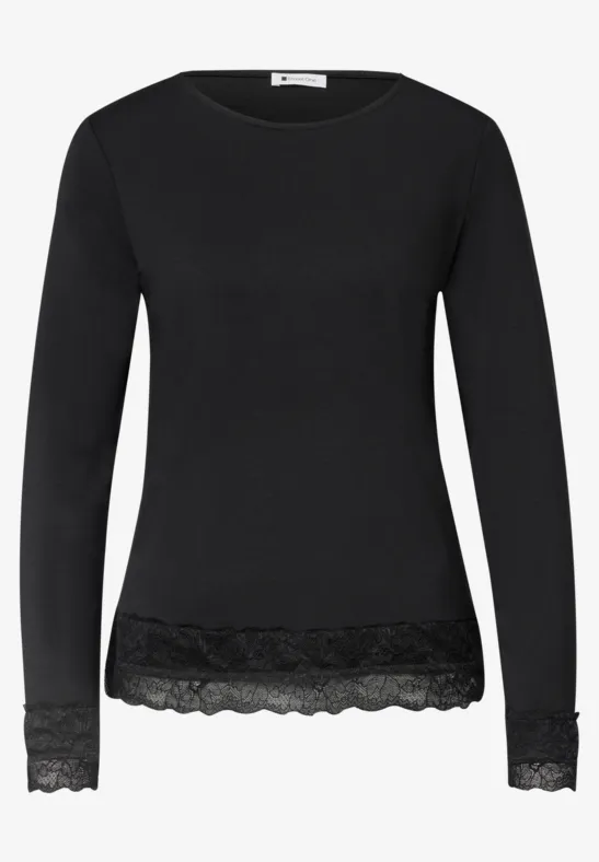 Schwarzes Langarmshirt mit Spitzenbesatz am Saum und an den Ärmelenden.