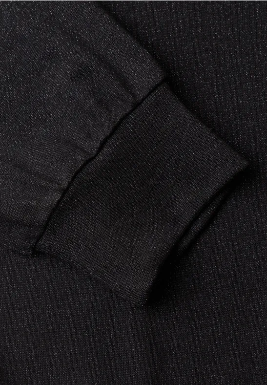 Nahaufnahme eines schwarzen Ärmelbündchens aus elastischem, geripptem Strickstoff.