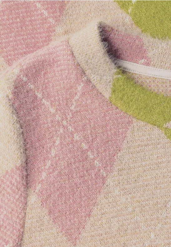 Nahe Aufnahme eines gestrickten Pullovers mit pastellfarbenem Rautenmuster in Pink, Grün und Beige.