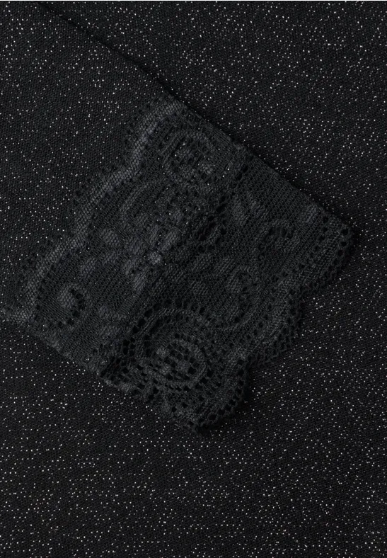 Gros plan sur un tissu noir à points scintillants et bordure en dentelle.