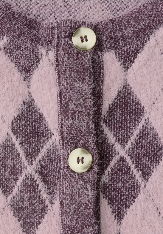 Nahaufnahme eines rosa-violetten Strickcardigans mit Rautenmuster und zwei Perlmuttknöpfen.