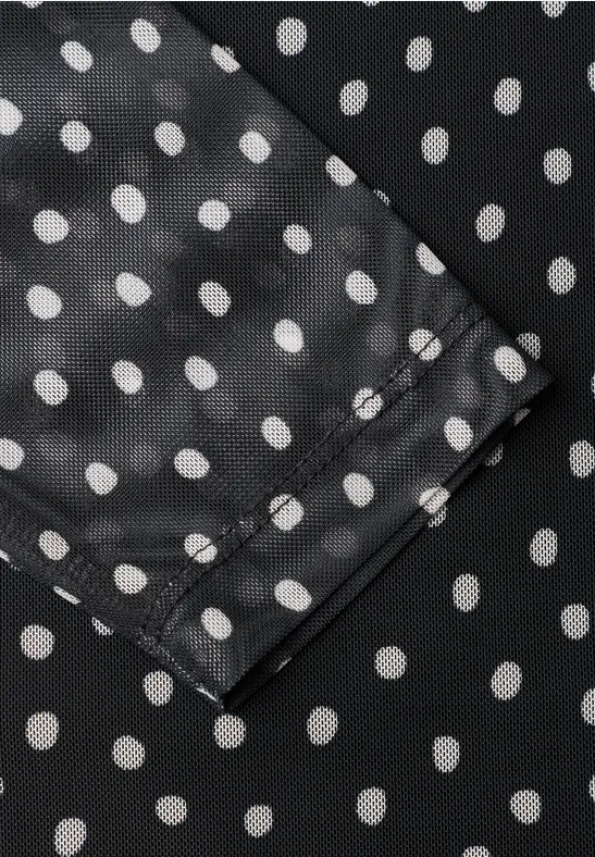 Schwarzer Stoff mit weißen Polka Dots und Naht, Detailansicht.