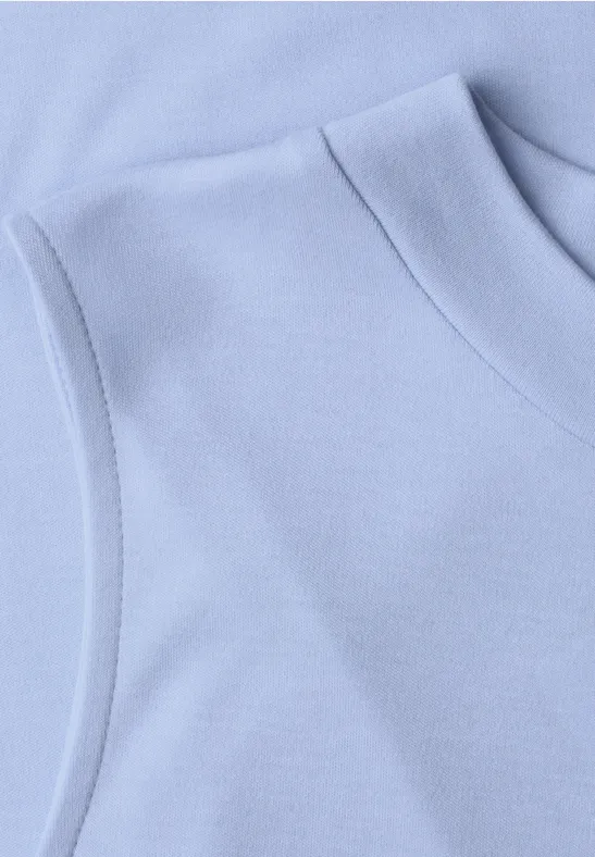 Detailaufnahme eines hellblauen ärmellosen Oberteils.