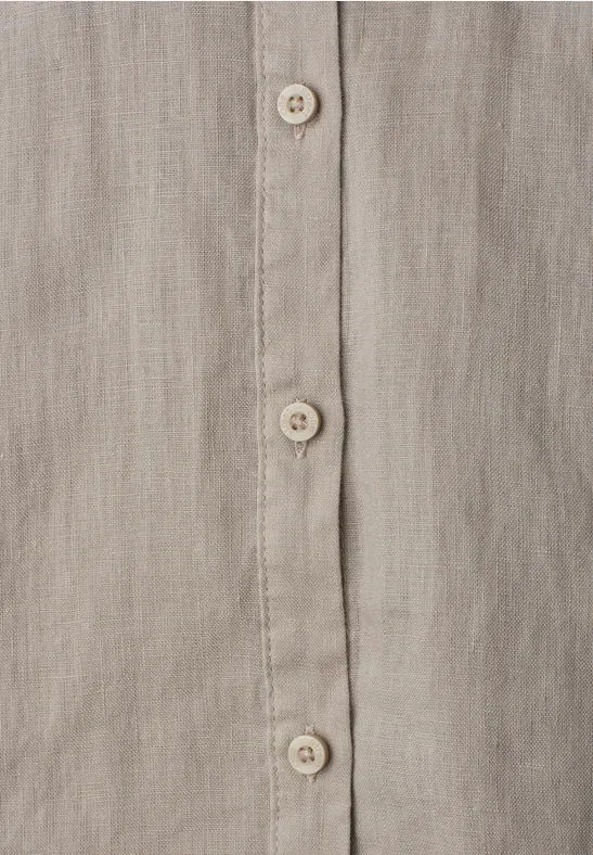 Nahaufnahme eines beige-grauen Leinenhemds mit Knopfleiste und cremefarbenen Knöpfen.
