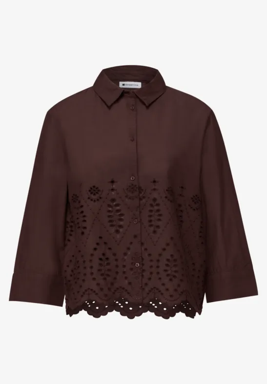 Chemise marron foncé aux manches 3/4, boutons sur le devant et broderie ajourée florale au bas.