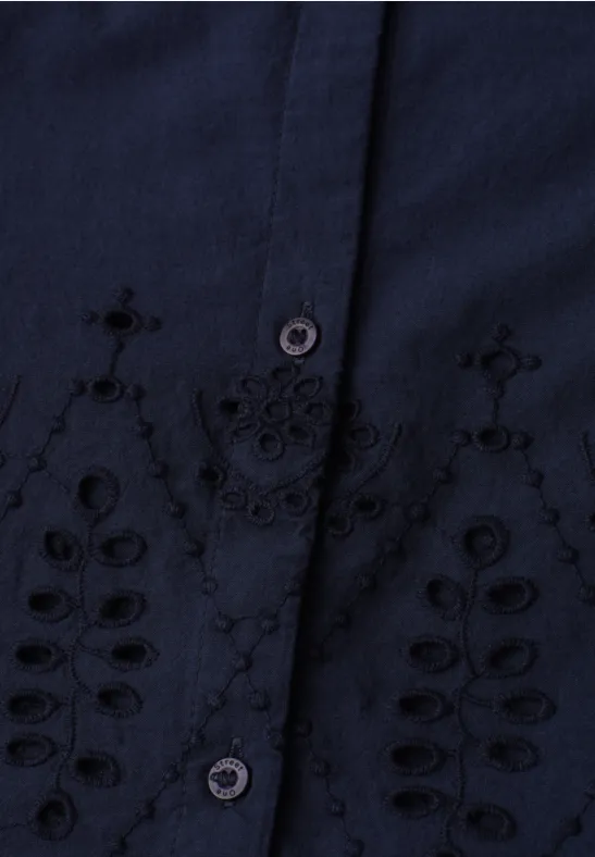 Donkerblauw bovenstuk met bloemrijke borduursels rond de knoopsluiting, speels opengewerkt motief.