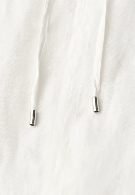 Witte koord met zilverkleurige uiteinden op licht stof.