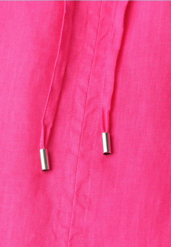 Close-up van roze stof met twee koorden en zilverkleurige metalen uiteinden.