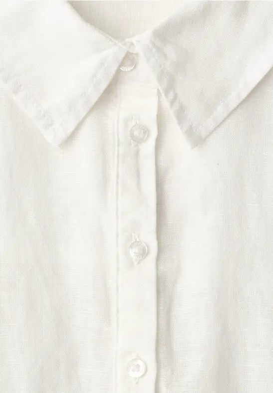 Close-up van een wit overhemd met knopenrij en klassieke kraag.