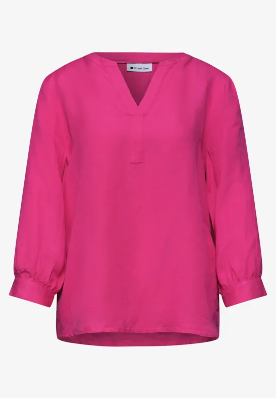 Losvallend felroze blouseje met V-hals en driekwart mouwen.