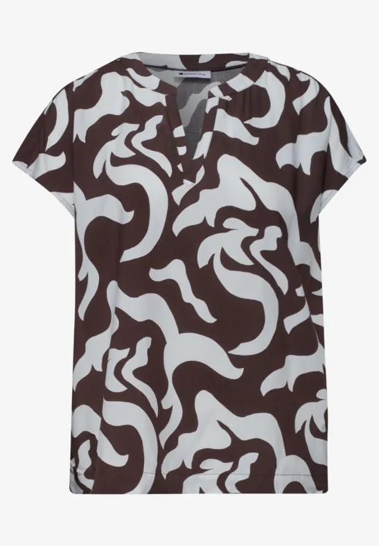 Kort bruin shirt met V-hals, versierd met lichtblauwe en witte abstracte patronen.
