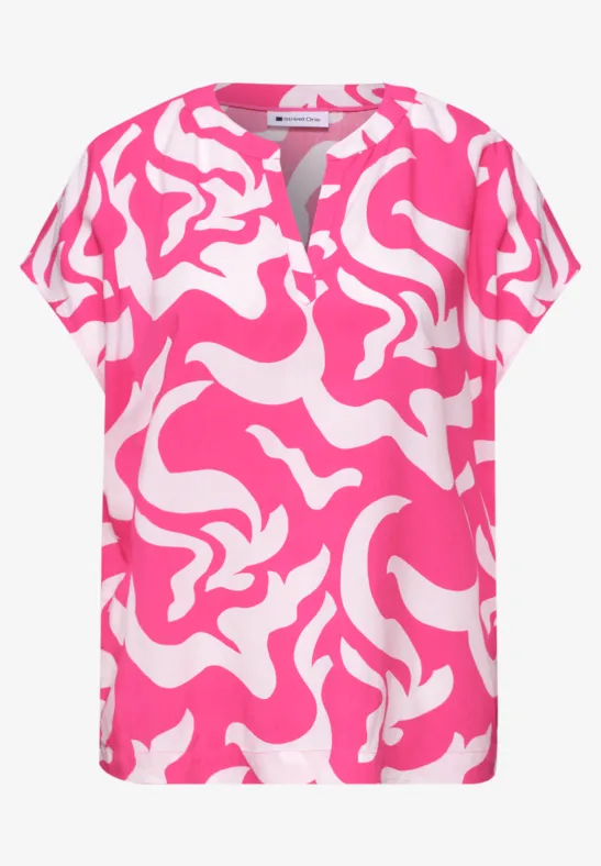 Damesblouse met korte mouw, roze-witte abstracte print en V-hals met split.