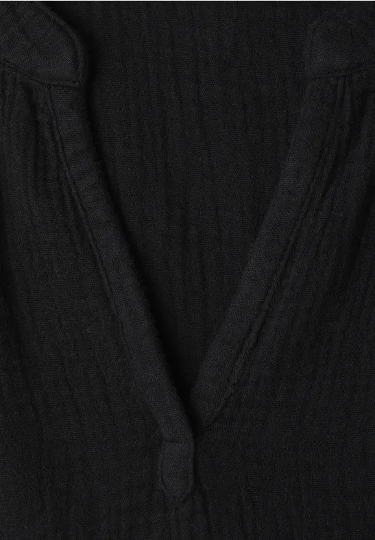 Zwart topje met V-hals van geribbelde stof.