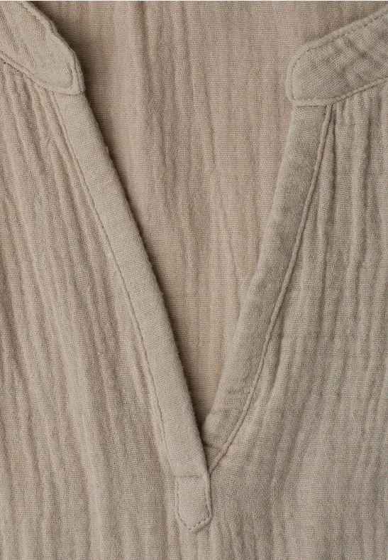 Beige linnen top met V-hals en gestructureerd oppervlak.