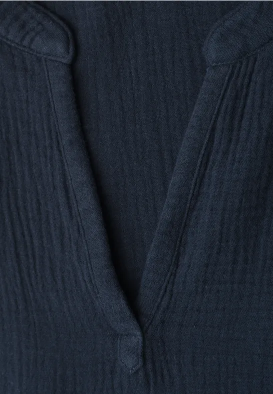 Nahaufnahme eines dunkelblauen, gerippten V-Ausschnitt-Shirts mit Knopfdetail