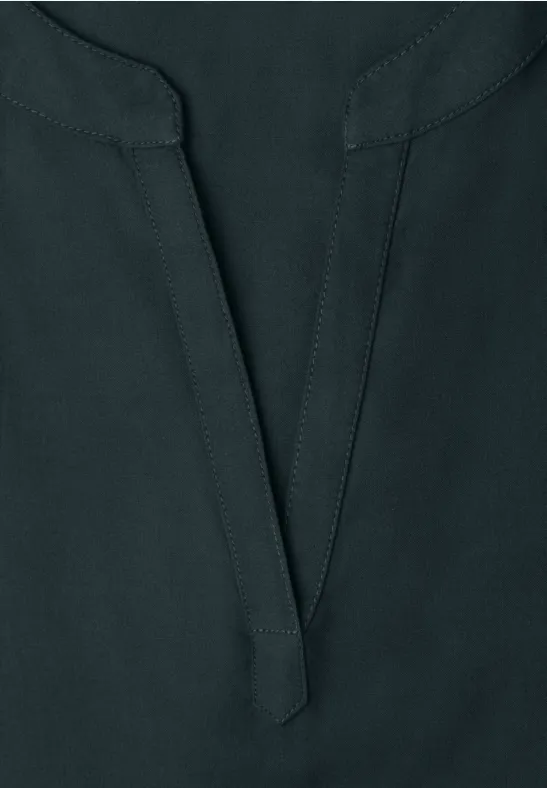 Dunkelblaues Oberteil aus leicht strukturiertem Stoff mit V-Ausschnitt und Nahtdetail in der Mitte.