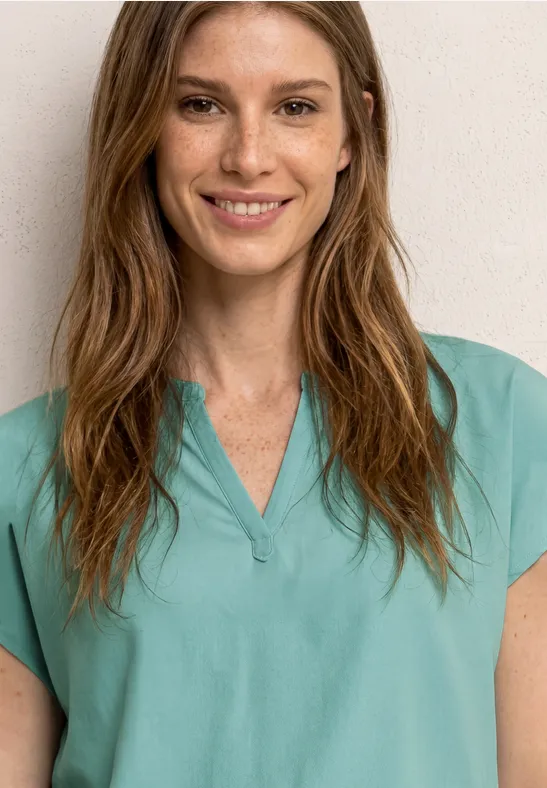 Femme en blouse médicale verte sur fond clair