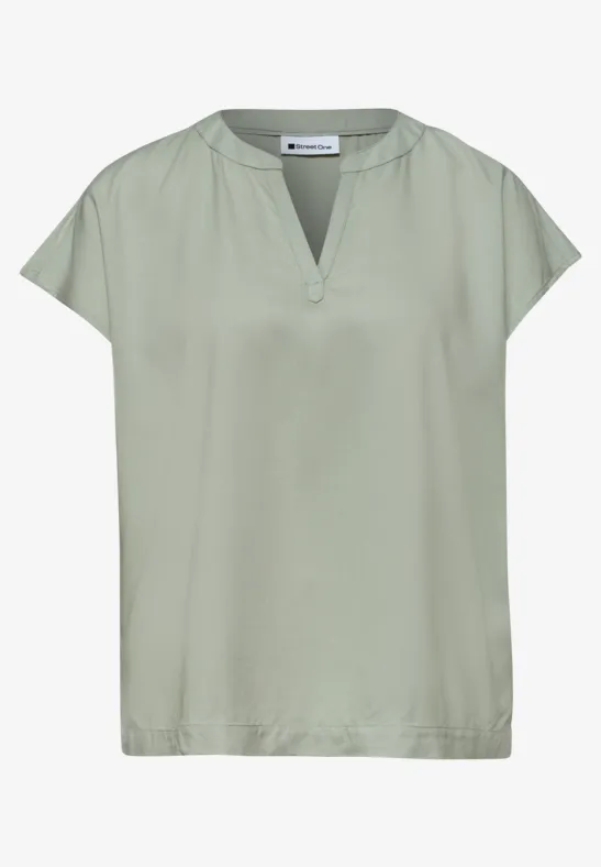 Leichte Bluse in Hellgrün mit kurzem Arm und V-Ausschnitt.