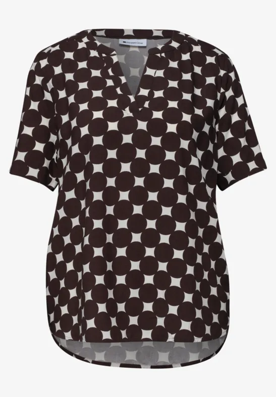 Schwarze Bluse mit weißem Kreismuster, V-Ausschnitt und kurzen Ärmeln.