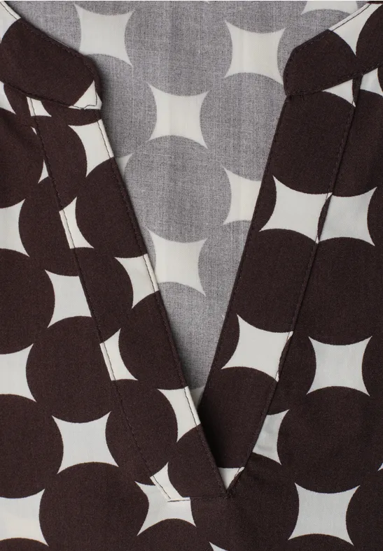 Dunkelbraunes Wickeloberteil mit auffälligem, weißem Kreisstern-Muster.