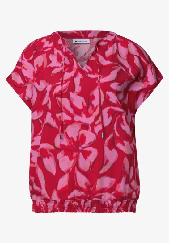 Rosa Bluse mit roten, abstrakten Blumenmustern, V-Ausschnitt und Tunnelzug am Saum.