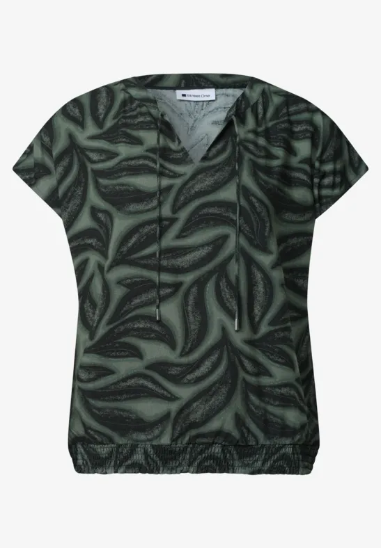 Dunkelgrünes, kurzärmeliges Damen-Shirt mit abstraktem Blattmuster.