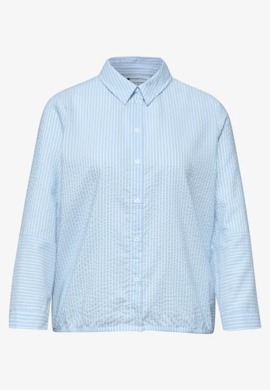 Lichtblauw hemd met fijn ruitpatroon, lange mouwen, klassieke kraag en losse pasvorm.