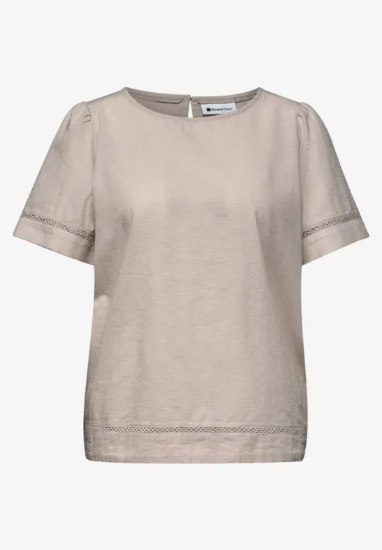 Beige dames top met korte mouwen, ronde hals en subtiele kanten boord.