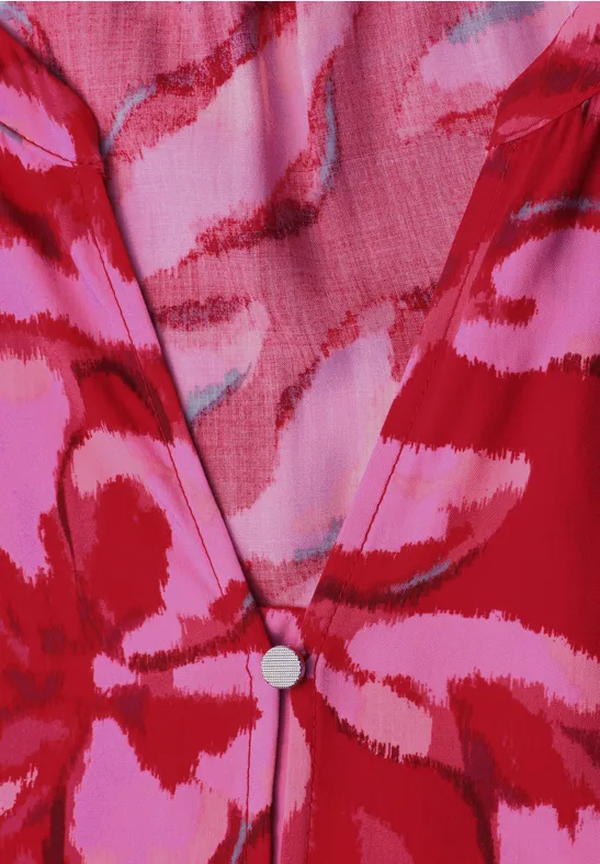 Rood-roze top met V-hals en abstracte penseelstreekprint.