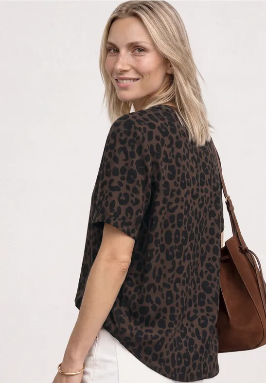 Frau im braun-schwarzen Leoparden-T-Shirt mit Schultertasche