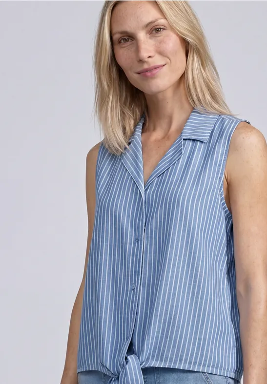 Vrouw draagt een mouwloze blauw-wit gestreepte top met kraag en knoop vooraan.
