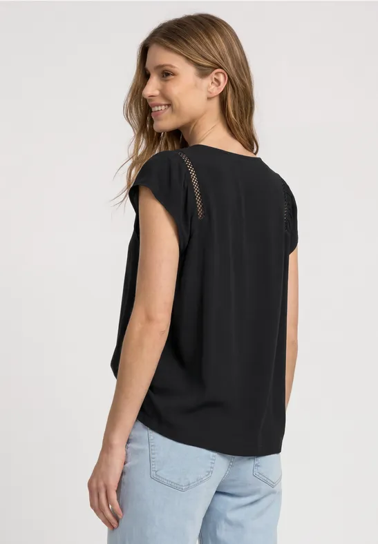 Femme de dos portant un t-shirt noir et un jean bleu clair.