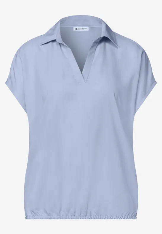 Hellblaues Shirt mit kurzen Ärmeln und V-Kragen für Damen.