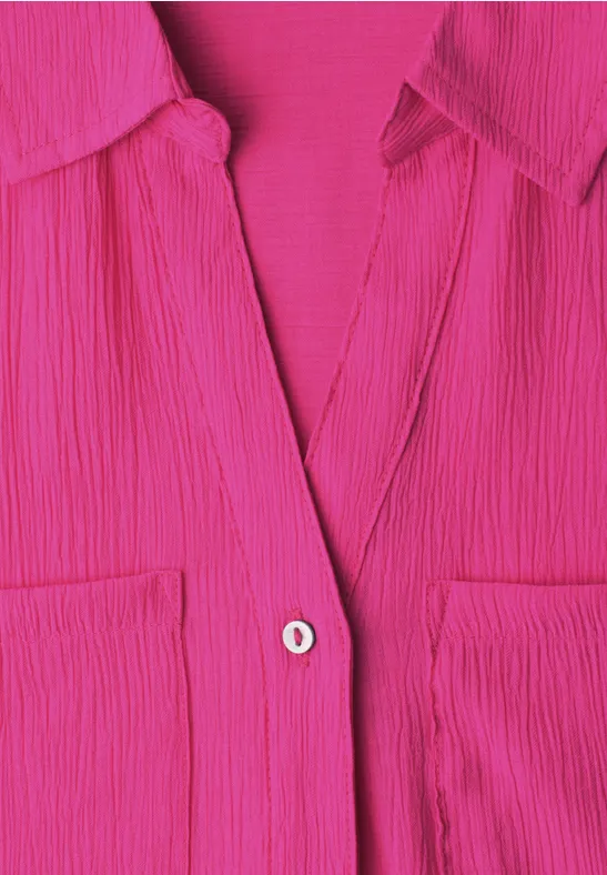 Felroze geplooide blouse met zakken en een knoop in het midden.