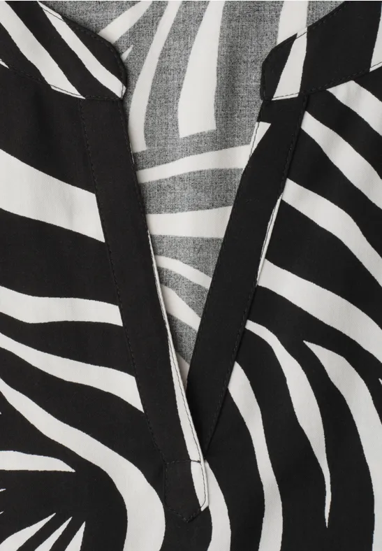 Zwart-wit zebraprint op stof met V-hals, grafische modeprint.