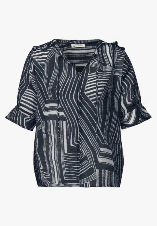 Zwart-witte damesblouse met V-hals, korte mouwen en abstract geometrisch patroon.