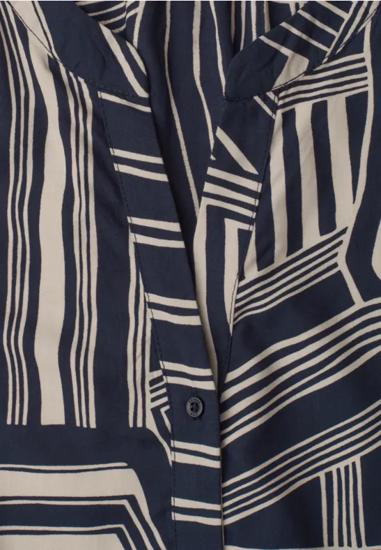 Detailaufnahme eines Kleidungsstücks mit marineblau-cremefarbenem, geometrischem Streifenmuster.