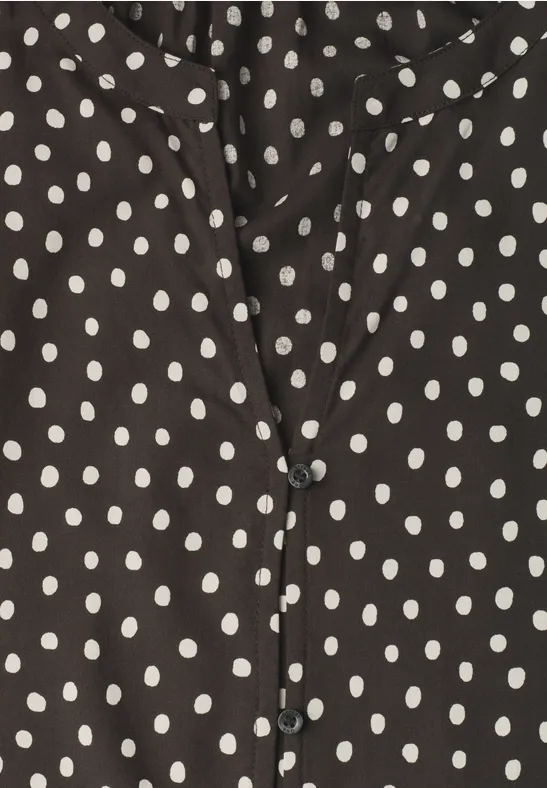 Schwarze Bluse mit weißen Punkten.