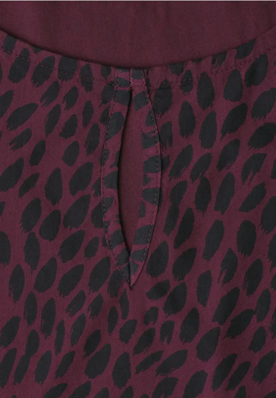 Bluse aus burgunderfarbenem Stoff mit schwarzem Blattmuster und kleinem Tropfenausschnitt am Halsausschnitt